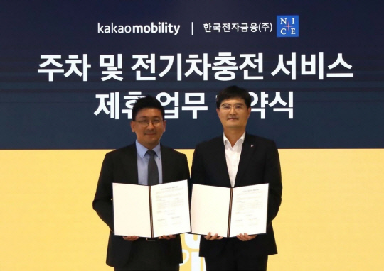 김재현(왼쪽) 카카오모빌리티 카오너사업실 상무와 임훈택 한국전자금융 주차사업본부 전무가 주차·전기차충전 서비스 제휴 업무 협약식에서 기념사진을 촬영하고 있다. 카카오모빌리티 제공